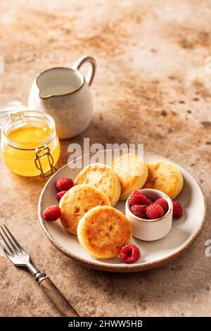 Pancake al formaggio caserma scirniki con lampone fresco su sfondo testurizzato Foto Stock