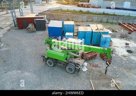 Sollevamento del trattore a gru in cantiere industriale. Macchinari per impieghi pesanti per l'edilizia. Foto Stock