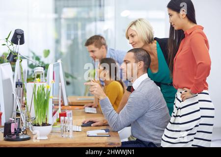 Ottenere una seconda opinione. Scatto di un grande gruppo di colleghi in ufficio. Foto Stock