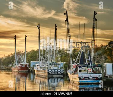 La pesca commerciale di imbarcazioni e natanti adibiti alla pesca di gamberetti legato fino al tramonto in Bayou La Batre Alabama, Stati Uniti d'America. Foto Stock