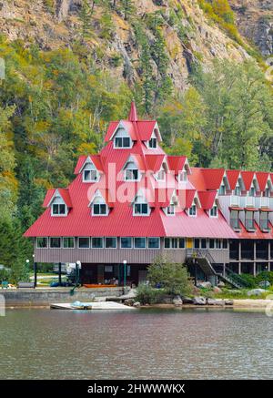 Bellissimo paesaggio di montagna e di lago con edifici rossi su una riva. Three Valley Gap Lake Chateau Hotel, BC, Canada-Settembre 26,2021. Viaggi Foto Stock