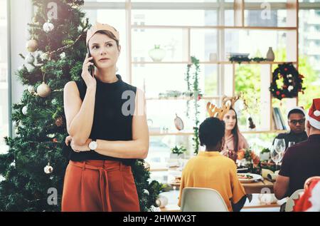 Im non molto sicuro se posso lasciare la casa ora.... Scatto corto di una giovane donna attraente che prende una phonecall con i suoi amici che mangiano in Foto Stock