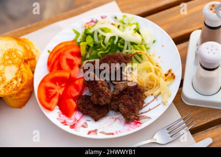 Kofte turco alla griglia di agnello con contorno di verdure Foto Stock