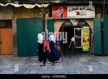 Donne palestinesi che camminano presso il ristorante Abu Shukri nel quartiere musulmano nella città vecchia di Gerusalemme. Foto Stock