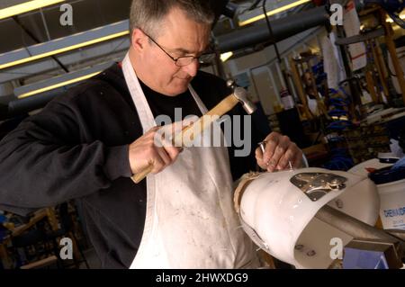 Un tecnico di protesi rivetta una presa in polipropilene per adattarsi comodamente al moncone del paziente (MODELLO RILASCIATO). Foto Stock