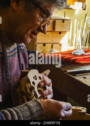 Carlos Roberts maestro liutaio violino creatore scegliere il ponte giusto per un nuovo violoncello della sua produzione presso la sua officina Foto Stock