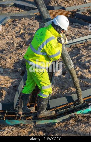 Appaltatori inb Preston, Lancashire. Meteo Regno Unito Marzo 2022. A temperature di 2,5 gradi Celsius, inizia il lavoro di fondazione sul sito Morar Car Home. Le temperature sono impostate per salire quando Technic concrete Pumping, una macchina idraulica £500.000, trasporta calcestruzzo bagnato da 15 betoniere che si prevede arriveranno al sito Preston Docks sulla navigazione. Il sito già impilato ora avrà 175 metri cubi di cemento come base per la struttura a due piani. Credit; MediaWorldImages/AlamyLiveNews Foto Stock