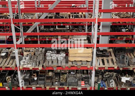 Parte di un ampio magazzino di distribuzione di impianti industriali con scaffali pieni di pezzi di ricambio per macchine e lavori di riparazione Foto Stock