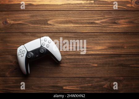 Controller Dualsense PS5 su sfondo in legno, concetto di gioco Foto Stock
