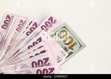 Duecento banconote turche con cento dollari americani e spazio per le copie su sfondo bianco.Vista dall'alto e mezza Foto Stock