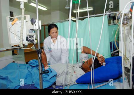 Questo paziente riceve liquidi endovenosi (iv) (nel braccio destro) e ossigeno tramite una cannula nasale. Indossa un ossimetro a impulsi sul suo indice fi destro Foto Stock