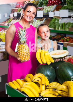 donna con bambino che acquista frutta Foto Stock