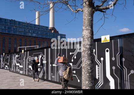 Due operai trasportano scatole simili dall'industria edile verso la centrale elettrica di Battersea sulla corsia della sede della pompa a Nine Elms, il 7th marzo 2022, a Londra, Inghilterra. Foto Stock