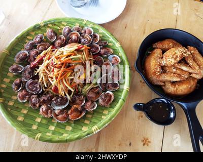 Tradizionale cibo thailandese nord-orientale fusion set o cucina isana locale pasto somtam con covolino bollito grossolanamente e fritto ala di pollo servire per la gente mangiare d Foto Stock