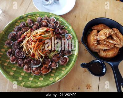 Tradizionale cibo thailandese nord-orientale fusion set o cucina isana locale pasto somtam con covolino bollito grossolanamente e fritto ala di pollo servire per la gente mangiare d Foto Stock