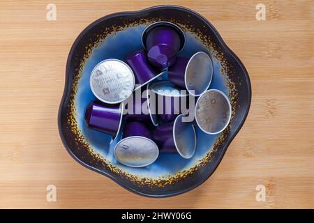 Nespresso inspirazione Italiana Firenze Arpeggio capsule di caffè intenso in ciotola su sfondo ligneo - caffè intenso e cremoso, cialde di caffè Foto Stock