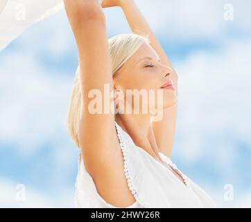 Un momento per respirare. Una bella giovane donna che tiene una sciarpa nella brezza. Foto Stock