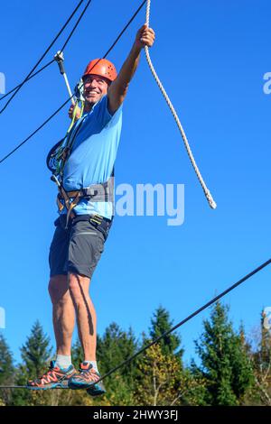 Uomo in equilibrio su ad alta fune funi in corso Foto Stock