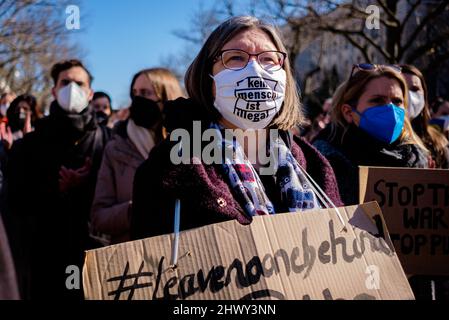 Berlino, Berlino, Germania. 8th Mar 2022. I manifestanti indossano una maschera facciale con la scritta "nessun essere umano è illegale” di fronte all'Ambasciata russa nel centro di Berlino in solidarietà con le donne e le loro famiglie in Ucraina e Russia in occasione della Giornata internazionale della donna del 2022 sotto lo slogan "Donne e madri di tutti i paesi - unitevi!” E 'No War divide noi'. Gli organizzatori sottolineano la situazione particolare delle donne e dei bambini in conflitto, con particolare attenzione alla guerra in corso in Ucraina e al movimento di protesta della società civile emergente in Russia. (Credit Image: © Jan Scheunert/ZUMA Press Wire) Foto Stock