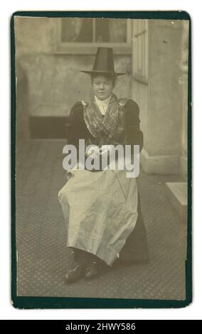 Victorian carte de Visite (CDV) o scheda di visita, di attraente giovane donna / ragazza più anziana, in costume gallese tradizionale, costume nazionale gallese, originariamente indossato da donne rurali, Ma alla fine del 19th secolo fu indossata per occasioni speciali come il festival di Eisteddfod (Eisteddfodau), cori e visite reali, che tiene in mano aghi e filati comuni in molte di queste foto. La ragazza indossa una scialle, un cappello nero alto e un abito o 'abito da letto'. Circa 1897, Galles, Regno Unito Foto Stock