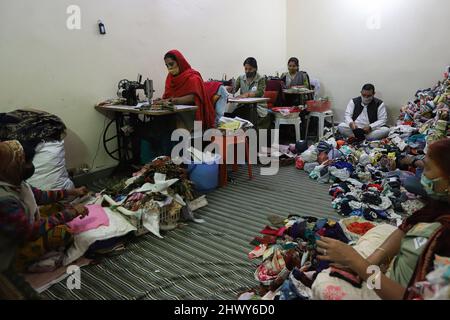 New Delhi, India. 07th Mar 2022. I dipendenti indiani delle donne fanno i tamponi sanitari riutilizzabili in tessuto di cotone in occasione della Giornata Internazionale delle Donne in una struttura all'interno del campus di Goonj (Organizzazione senza scopo di lucro) a New Delhi.The ONG (Organizzazione non governativa) mira a fornire l'accesso ai cuscinetti sanitari a basso costo e campagne per porre fine ai tabù che circondano le mestruazioni nella società indiana conservatrice. Credit: SOPA Images Limited/Alamy Live News Foto Stock