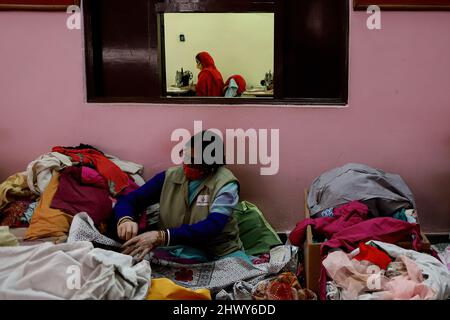 New Delhi, India. 07th Mar 2022. L'impiegato indiano misura pezzi di tessuto di cotone donati per fare tamponi igienici riutilizzabili in occasione della Giornata Internazionale della Donna in una struttura all'interno del campus di Goonj (Organizzazione senza scopo di lucro) a New Delhi.The ONG (Organizzazione non governativa) Mira a fornire l'accesso ai cuscinetti sanitari economici e campagne per porre fine ai tabù che circondano le mestruazioni nella società indiana conservatrice. Credit: SOPA Images Limited/Alamy Live News Foto Stock