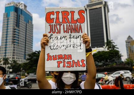 Jakarta, Indonesia. 08th Mar 2022. Un attivista tiene un cartello durante la protesta sulla Giornata Internazionale delle Donne. Gli attivisti delle Donne si radunano nella Giornata Internazionale delle Donne nella zona di Monas, Jakarta. La massa chiede al governo di attuare un sistema di protezione sociale che non discrimina le donne. Credit: SOPA Images Limited/Alamy Live News Foto Stock