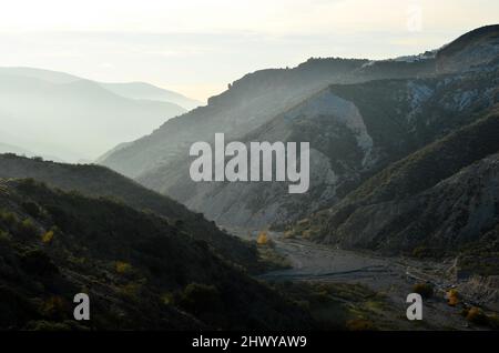 Aride pendici meridionali della Sierra Nevada si staglia contro la luce solare invernale, Alpujarras regione Almeria Spagna meridionale. Foto Stock
