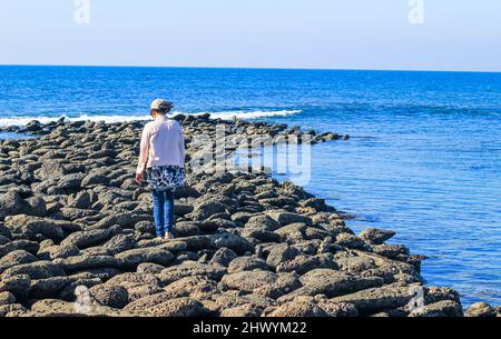 Una ragazza turistica che cammina sul gigante's Causeway a St. Martin's Island, Bangladesh. L'alba magica, le nuvole e le onde che colpiscono la costa. Selciato del gigante. Foto Stock