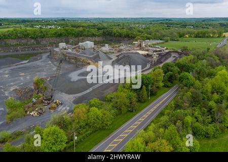 Vista dall'alto, panorama dei lavori di macchinari per l'estrazione di opencast pesanti in una cava di pietra Foto Stock