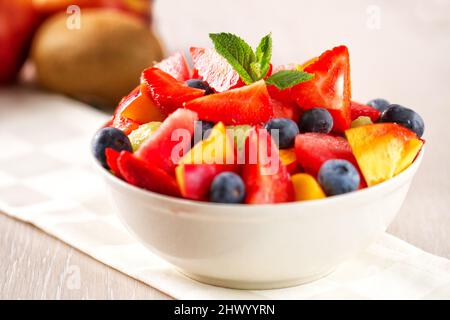 Macedonia di frutta fresca con fragole, melone di mirtilli e pesche Foto Stock