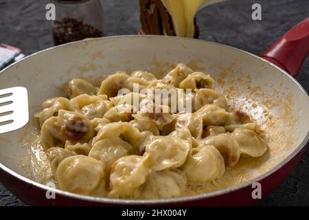 deliziosi ravioli fritti dorati in una padella sul tavolo. Gnocchi fritti per cena. Foto Stock