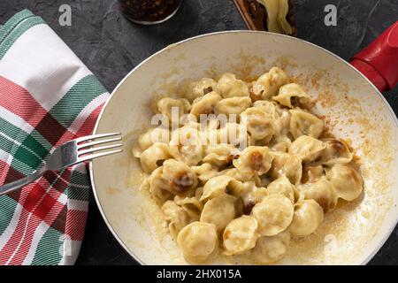 deliziosi ravioli fritti dorati in una padella sul tavolo. Gnocchi fritti per cena. Foto Stock