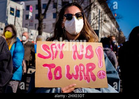 Berlino, Germania. 8th Mar 2022. Un portesters ha un banner che dice "Say no to war!" Di fronte all'Ambasciata russa nel centro di Berlino in solidarietà con le donne e le loro famiglie in Ucraina e Russia in occasione della Giornata internazionale della donna del 2022 sotto lo slogan "Donne e madri di tutti i paesi - unitevi!” E 'No War divide noi'. Gli organizzatori sottolineano la situazione particolare delle donne e dei bambini in conflitto, con particolare attenzione alla guerra in corso in Ucraina e al movimento di protesta della società civile emergente in Russia. (Credit Image: © Jan Scheunert/ZUMA Press Wire) Foto Stock