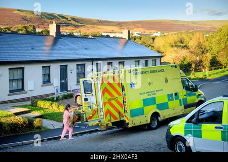 I paramedici spostano un paziente nella loro ambulanza dopo l'esame del paziente nella loro sede vicino Pontypool, S. Galles Regno Unito Foto Stock