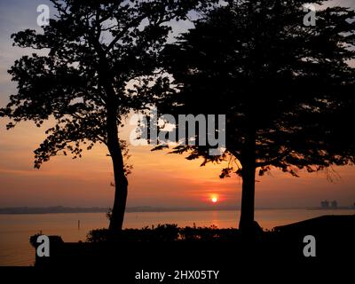 Tramonto sull'acqua di Southampton e sulla New Forest, vista da Netley, Hampshire. Foto Stock