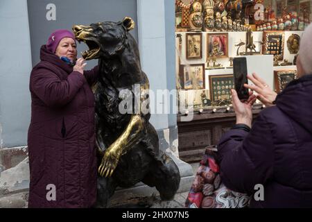 Mosca, Russia. 8th marzo 2022 Una donna è fotografata con una scultura di un orso in un negozio di souvenir in via Nikolskaya nel centro di Mosca, Russia Foto Stock
