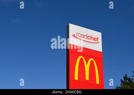 Carmarthen, Galles - Marzo 2022: Grande cartello che fa pubblicità a McDonalds all'ingresso di una stazione di servizio autostradale gestita da Roadchef Foto Stock