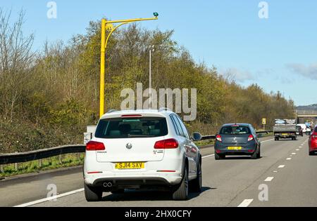 Bridgend, Galles - Marzo 2022: Auto sull'autostrada M4 passando sotto una telecamera a velocità media. I limiti di velocità su parti della strada sono stati ridotti Foto Stock