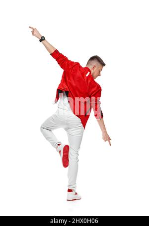 giovane uomo in piedi danzando gambe alzanti che spargono le mani Foto Stock