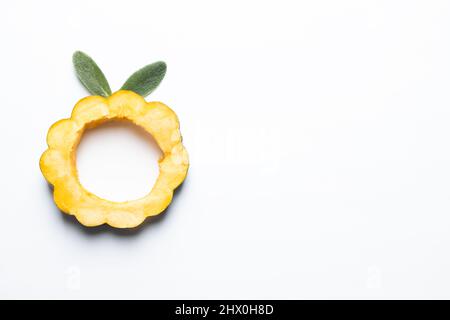 Squash di ghiande affettato con foglie di orecchio degli agnelli isolato su uno sfondo bianco. Foto Stock