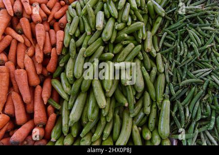 Carote, zucchine, piselli sul banco del mercato egiziano. Verdure fresche nel bazar di strada Foto Stock