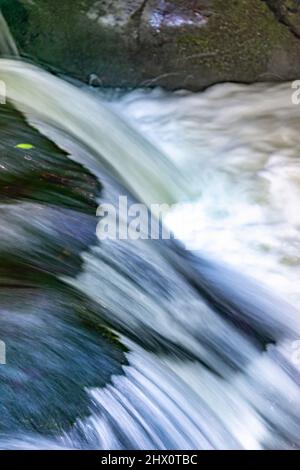 Vista astratta delle cascate d'acqua con sfocatura del movimento in una serie di spettacolari cascate e cascate, lungo una sezione del fiume Fowey, un popolare tour Foto Stock