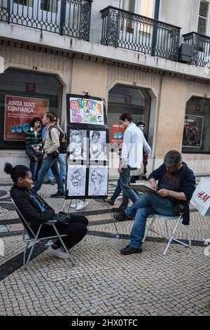 Artista di caricatura a Lisbona, disegnando una donna cliente Foto Stock