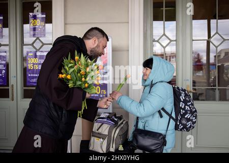 Przemysl, Polonia. 08th Mar 2022. Un sacerdote consegna fiori ai rifugiati alla stazione ferroviaria di Przemysl. Più di 1,5 milioni di ucraini sono fuggiti dal loro paese in Polonia a causa dell'invasione russa, secondo le ultime cifre dell'Alto Commissariato delle Nazioni Unite per i rifugiati (UNHCR). Credit: SOPA Images Limited/Alamy Live News Foto Stock