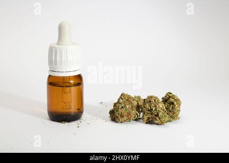 set di boccioli di marijuana, con flacone dispenser, fondo bianco. Foto Stock