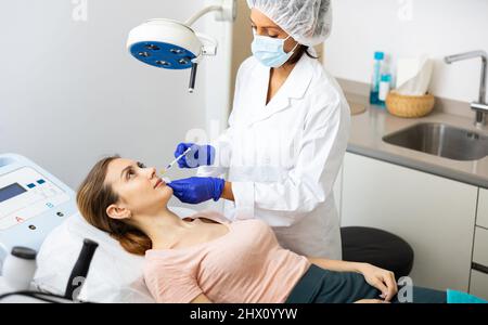 Paziente femmina che ottiene l'iniezione di bellezza per le labbra Foto Stock