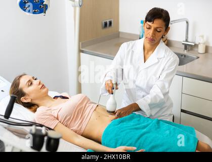 Donna che ha cavitazione procedura Foto Stock