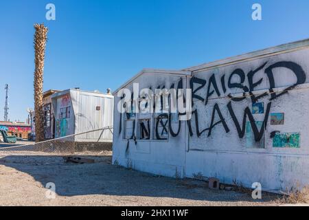 'momma ha sollevato un fuorilegge' graffiti spray dipinta su un edificio, una casa mobile, nell'insediamento di Bombay Beach, California, vicino al Mare di Salton. Foto Stock