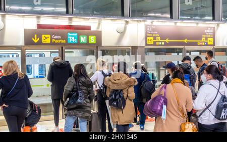 Passeggeri viaggiatori la gente aspetta il treno per Teminal D al terminal delle partenze all'interno dell'aeroporto Madrid-Barajas, Spagna Foto Stock